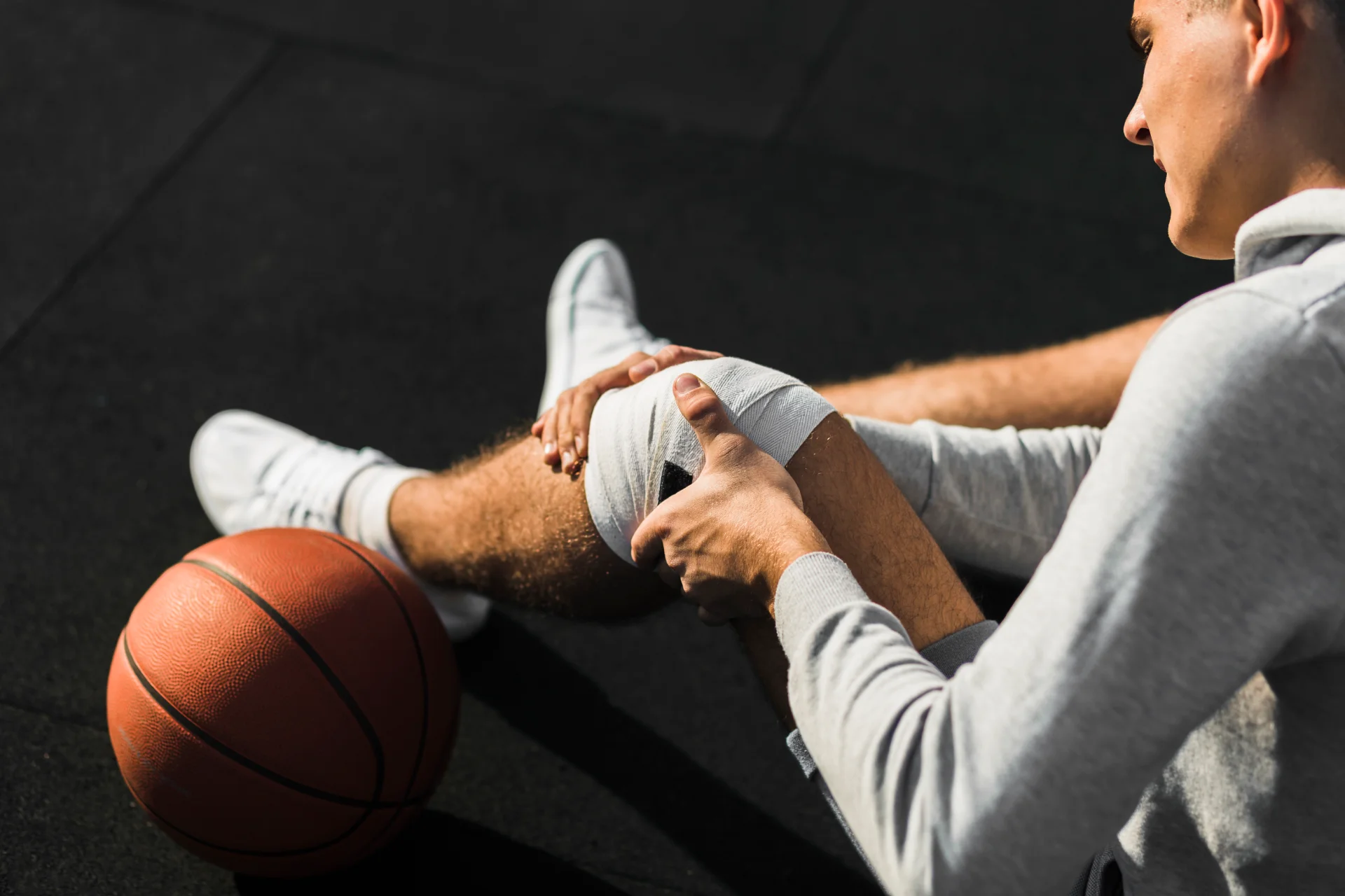 basketball player applying bandage knee